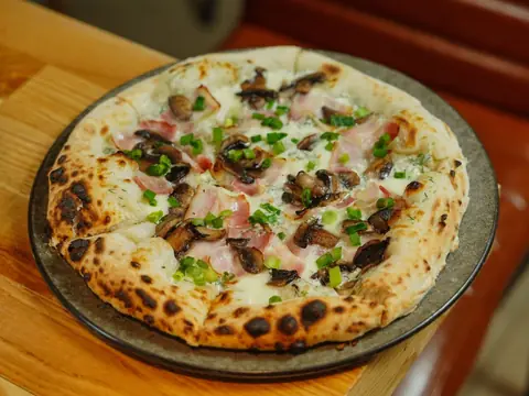 Pizza so šunkou, šampiňónmi a zelenou cibuľkou